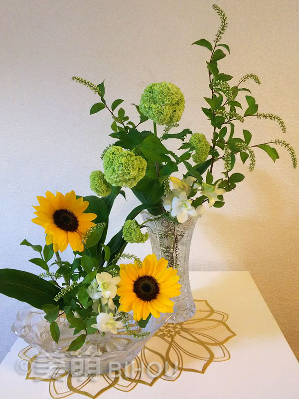 作品例：初夏の花　複数花器にいける　花材：ひまわり・りょうぶ・デンファレラン・ビバー
ナム　花器：ガラス花器末広がり型・ガラスフルーツ盛皿